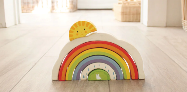wood rainbow stacking toy on a floor